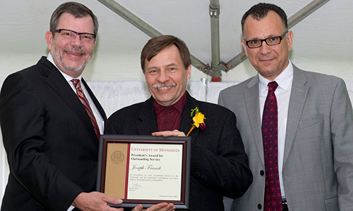 Joseph (Joe) Franek poses with President Eric Kaler and Professor Fotis Sotiropoulos, representing the President's Award for Outstanding Service Committee. Franek is holding his certificate.