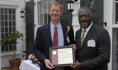 Kenneth L. Gilbertson poses with , Senior Vice President for Academic Administration. Gilbertson is holding his award certificate. 