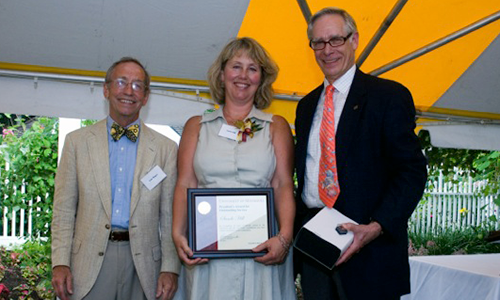 Sande Hill poses with President Robert H. Bruininks and Professor Pete Magee. Hill is holding her award certificate.