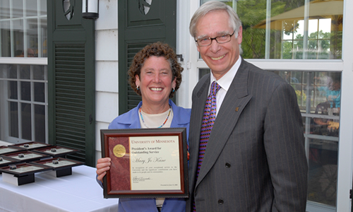 Mary Jo Kane poses with President Robert H. Bruininks. Kane is holding her award certificate.