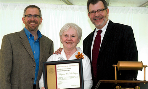 Margaret O'Neill Ligon poses with President Eric Kaler and Professor William Tolman, chair of the President's Award for Outstanding Service Committee. O'Neill Ligon is holding her certificate.