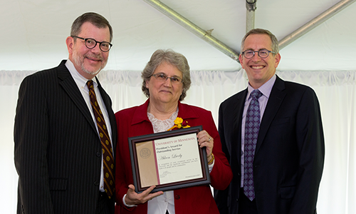 Aileen Lively poses with President Eric Kaler and Professor William Tolman, chair of the President's Award for Outstanding Service Committee. Lively is holding her certificate.