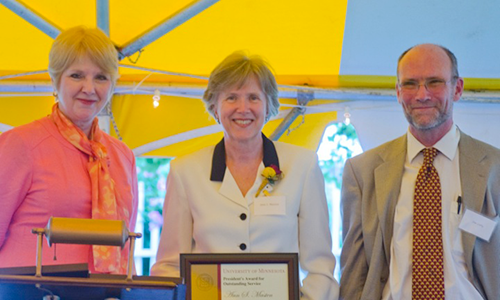 Ann S. Masten poses with Executive Vice President and Provost Karen Hanson and Professor James Luby, chair of the President's Award for Outstanding Service Committee. Masten is holding her certificate.