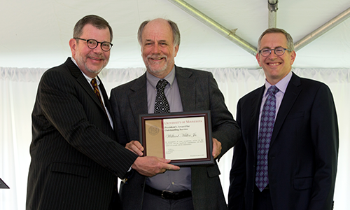 Peter Olver poses with President Eric Kaler and Professor William Tolman, chair of the President's Award for Outstanding Service Committee. Olver is holding his certificate.