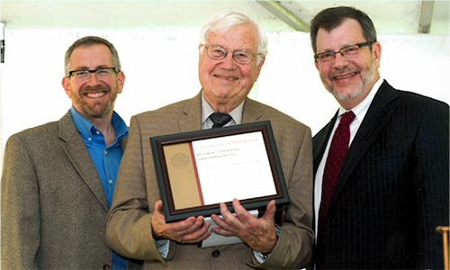 Neal C. Nickerson Jr. poses with President Eric Kaler and Professor William Tolman, chair of the President's Award for Outstanding Service Committee. Nickerson is holding his certificate.