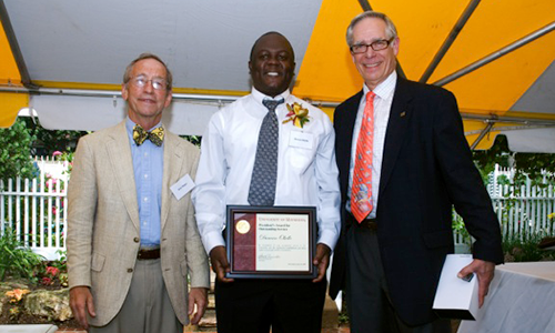 Duncan Okello poses with President Robert H. Bruininks and Professor Pete Magee. Okello is holding his award certificate.