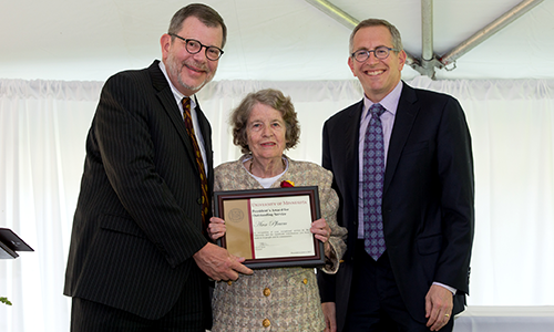 Ann Pflaum poses with President Eric Kaler and Professor William Tolman, chair of the President's Award for Outstanding Service Committee. Pflaum is holding her certificate.