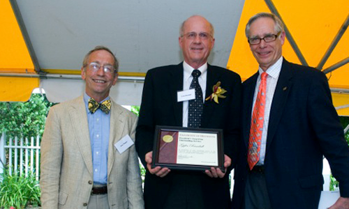 Gyles Randall poses with President Robert H. Bruininks and Professor Pete Magee. Randall is holding his award certificate.
