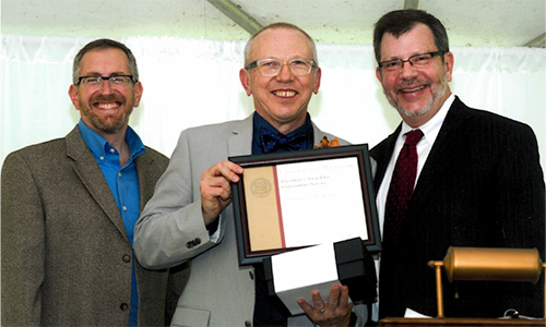 Duane Rohovit poses with President Eric Kaler and Professor William Tolman, chair of the President's Award for Outstanding Service Committee. Rohovit is holding his certificate.