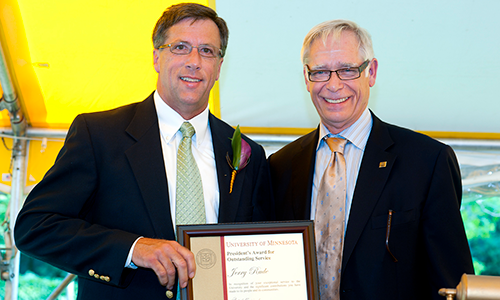 Jerry Rude poses with President Robert Bruininks. Rude is holding his certificate.