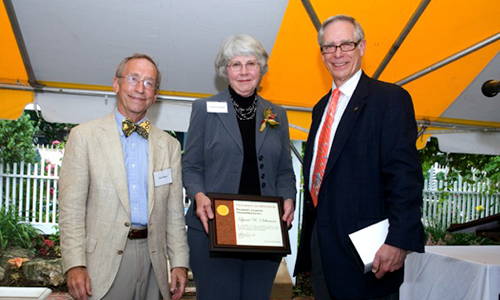 Lynne R. Schuman poses with President Robert H. Bruininks and Professor Pete Magee. Schuman is holding his award certificate.