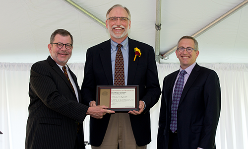 Robert Seybold poses with President Eric Kaler and Professor William Tolman, chair of the President's Award for Outstanding Service Committee. Seybold is holding his certificate.