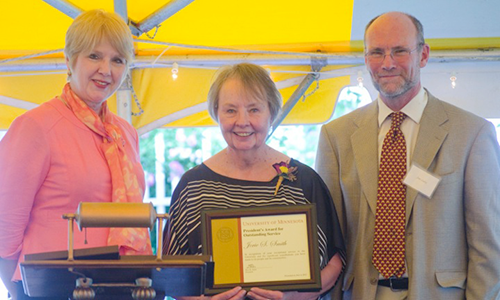 Jerie S. Smith poses with Executive Vice President and Provost Karen Hanson and Professor James Luby, chair of the President's Award for Outstanding Service Committee. Smith is holding her certificate.
