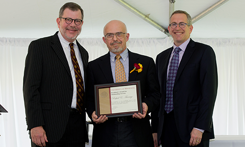 Rafael E. Tarrago poses with President Eric Kaler and Professor William Tolman, chair of the President's Award for Outstanding Service Committee. Tarrago is holding his certificate.