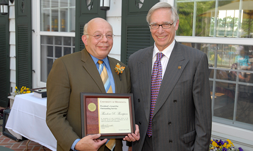 Theodore R. Thompson poses with President Robert H. Bruininks. Thompson is holding his award certificate.