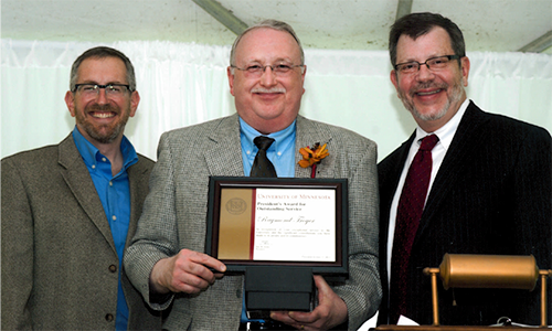 Raymond Troyer poses with President Eric Kaler and Professor William Tolman, chair of the President's Award for Outstanding Service Committee. Tryoyer is holding his certificate.