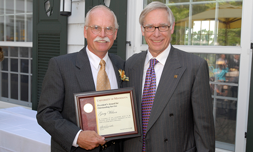 Gary Wilson poses with President Robert H. Bruininks. Wilson is holding his award certificate.