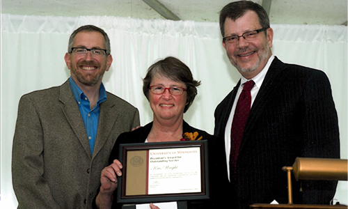 Kris Wright poses with President Eric Kaler and Professor William Tolman, chair of the President's Award for Outstanding Service Committee. Wright is holding her certificate.