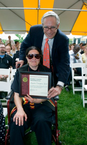 Jacqueline "Jaki" Cottingham-Zierdt posing with President Robert H. Bruininks. Cottingham-Zierdt holds her award certificate.