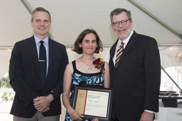 Molly Dingel poses with President Eric Kaler and Professor Robert Geraghty, chair of the President's Award for Outstanding Service Committee. Dingel is holding her certificate.