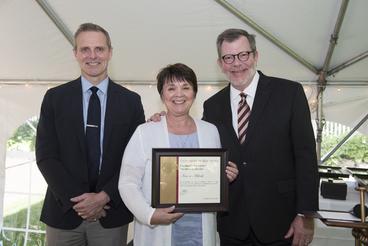 Heidi Barajas poses with President Eric Kaler and Professor Robert Geraghty, chair of the President's Award for Outstanding Service Committee. Heidi is receiving the award on behalf of Karen Miksch who could not attend. Barajas  is holding Miksch's certificate.