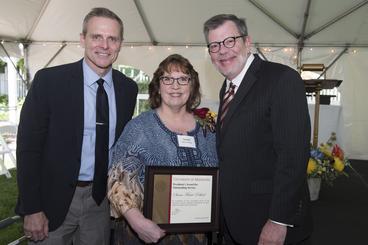 Susan Marie Pohlod poses with President Eric Kaler and Professor Robert Geraghty, chair of the President's Award for Outstanding Service Committee. Marie Pohlod is holding her certificate.