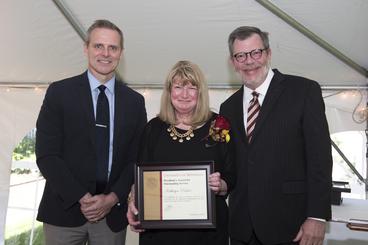 Kathryn Pouliot poses with President Eric Kaler and Professor Robert Geraghty, chair of the President's Award for Outstanding Service Committee. Pouliot is holding her certificate.