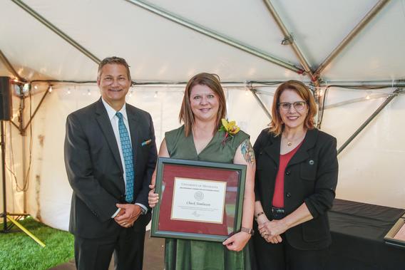 Photo of Heather Eastlund with President Joan Gabel and Professor Mark Distefano, chair, President's Award for Outstanding Service Committee, receiving the award on behalf of Chuck Tomlinson who was unable to attend the reception