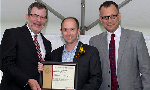 Skeeter Burroughs poses with President Eric Kaler and Professor Fotis Sotiropoulos, representing the President's Award for Outstanding Service Committee. Burroughs is holding his certificate.