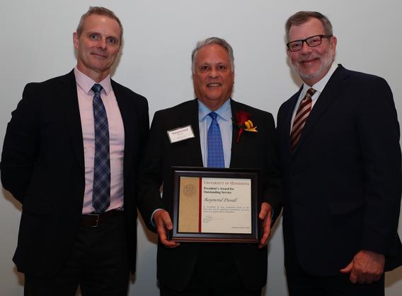 Recipient Raymond Duvall receiving his award pictured with President Eric W. Kaler and Robert Geraghty, chair, President's Award committee.