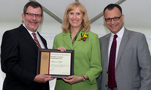 Sharon Dzik poses with President Eric Kaler and Professor Fotis Sotiropoulos, representing the President's Award for Outstanding Service Committee. Dzik is holding her certificate.
