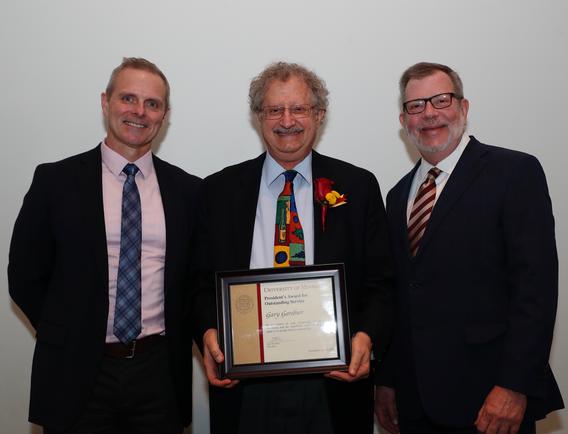 Recipient Gary Gardner receiving his award pictured with President Eric W. Kaler and Robert Geraghty, chair, President's Award committee.