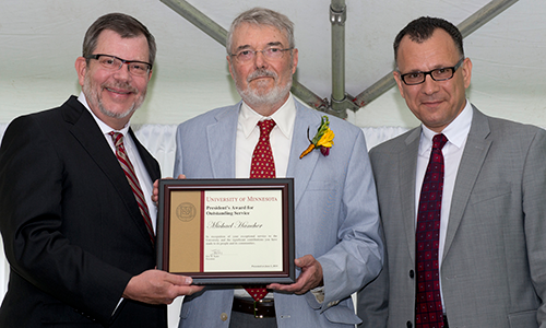 Michael Hancher poses with President Eric Kaler and Professor Fotis Sotiropoulos, representing the President's Award for Outstanding Service Committee. Hancher is holding his certificate.