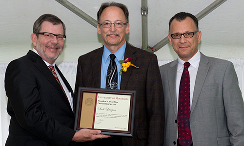 Scott Lanyon poses with President Eric Kaler and Professor Fotis Sotiropoulos, representing the President's Award for Outstanding Service Committee. Lanyon is holding his certificate.