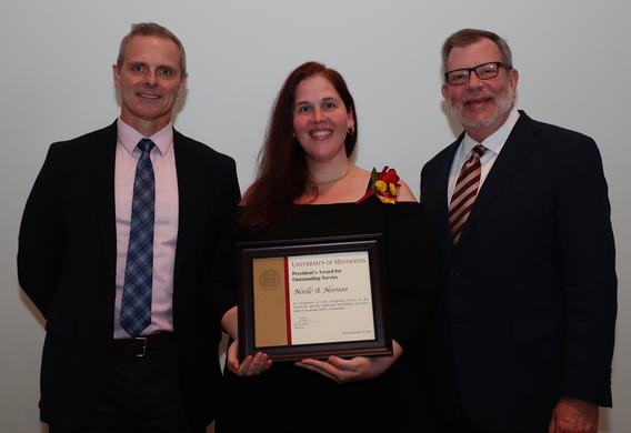 Recipient Noelle Noonan receiving her award pictured with President Eric W. Kaler and Robert Geraghty, chair, President's Award committee.