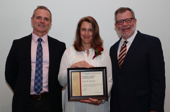 Recipient Lisa Warren receiving her award pictured with President Eric W. Kaler and Robert Geraghty, chair, President's Award committee.