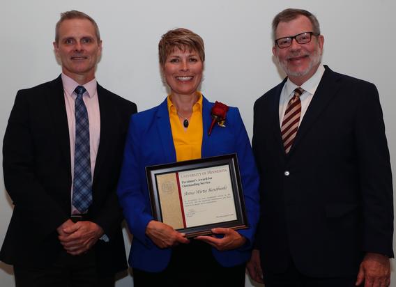 Recipient Anna Wirta Kosobuski receiving her award pictured with President Eric W. Kaler and Robert Geraghty, chair, President's Award committee.